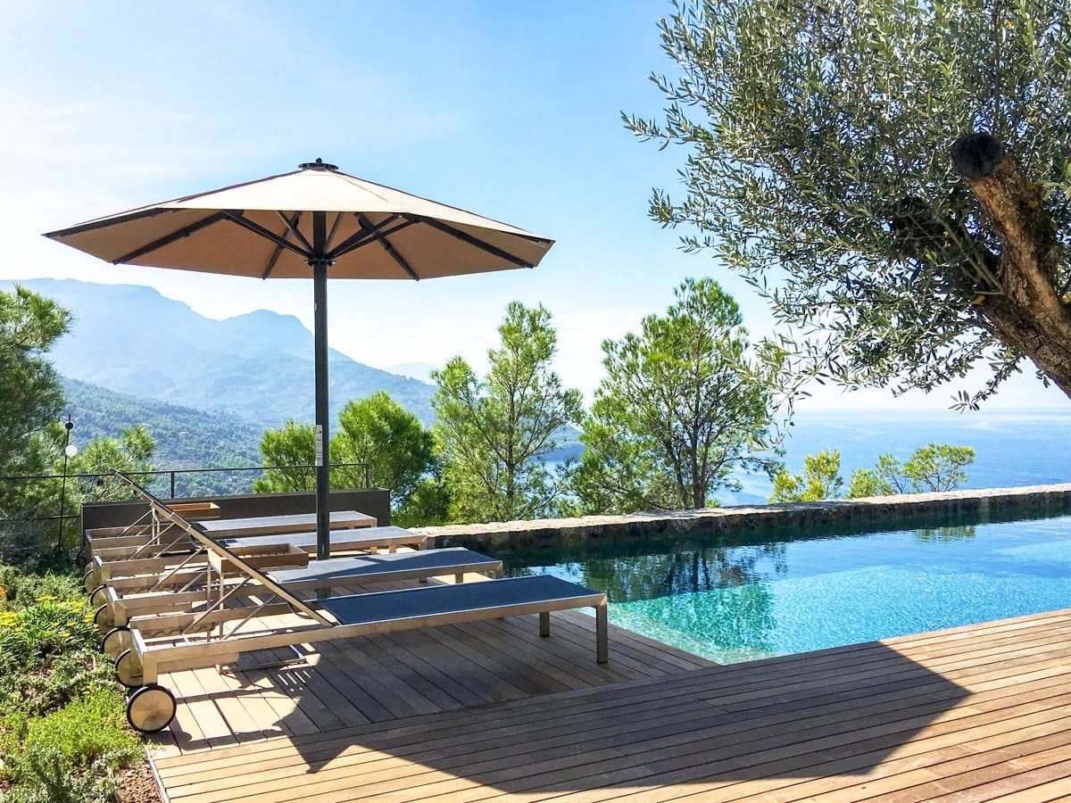 Großer Sonnenschirm über Poolliegen mit Panoramaaussicht